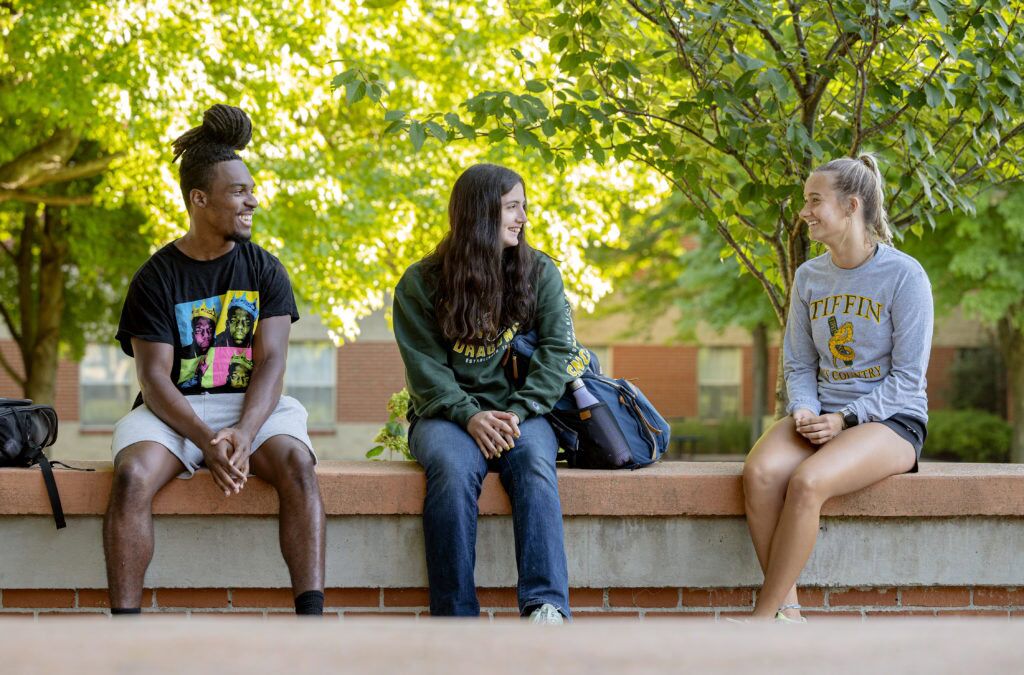 Group of smiling students sitting outside
