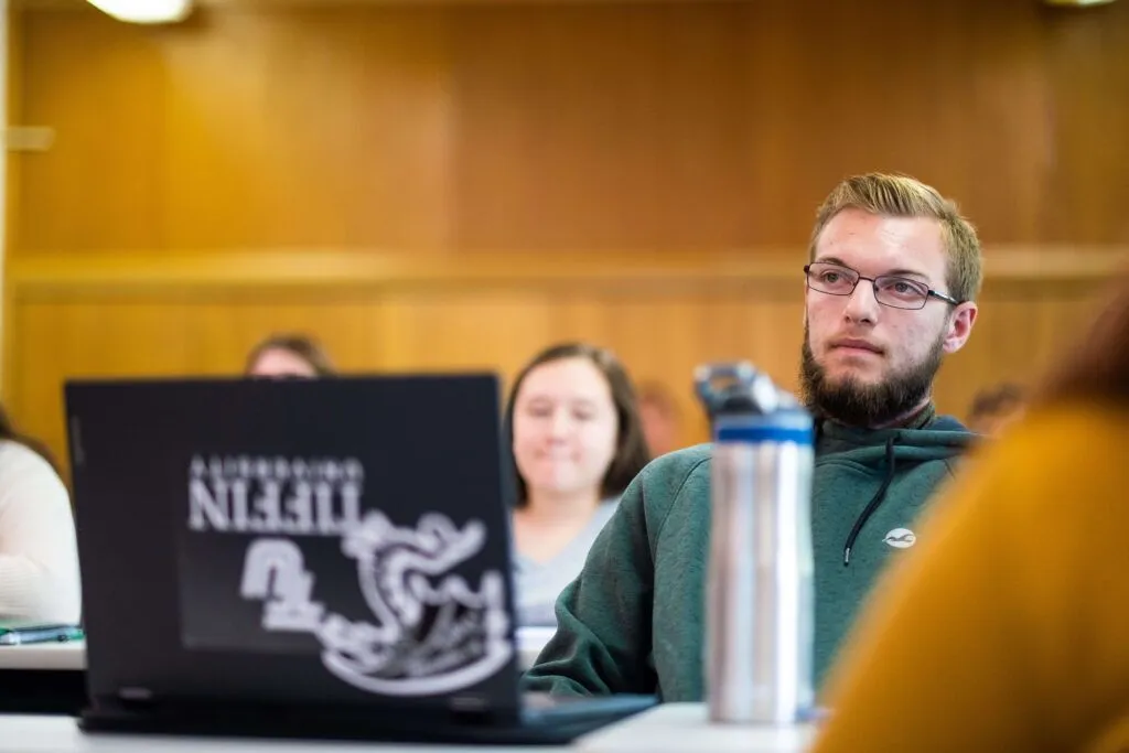 student in class with laptop