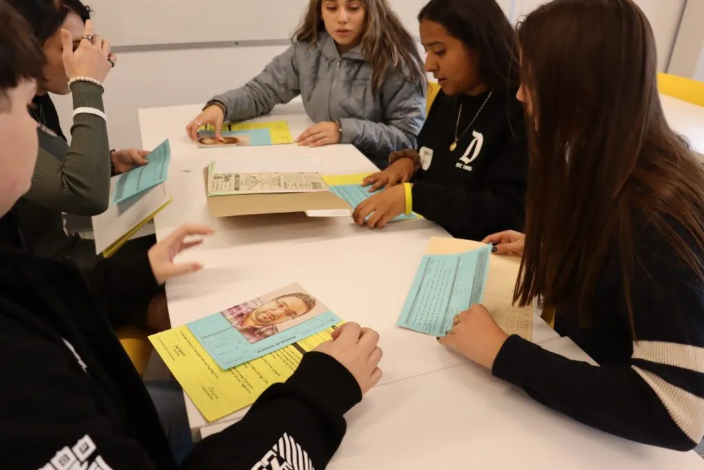 students working on a cold case sitting at a table with papers