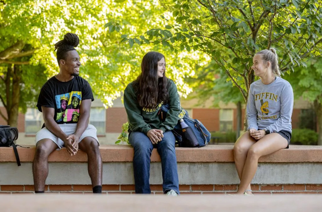 Group of smiling students sitting outside