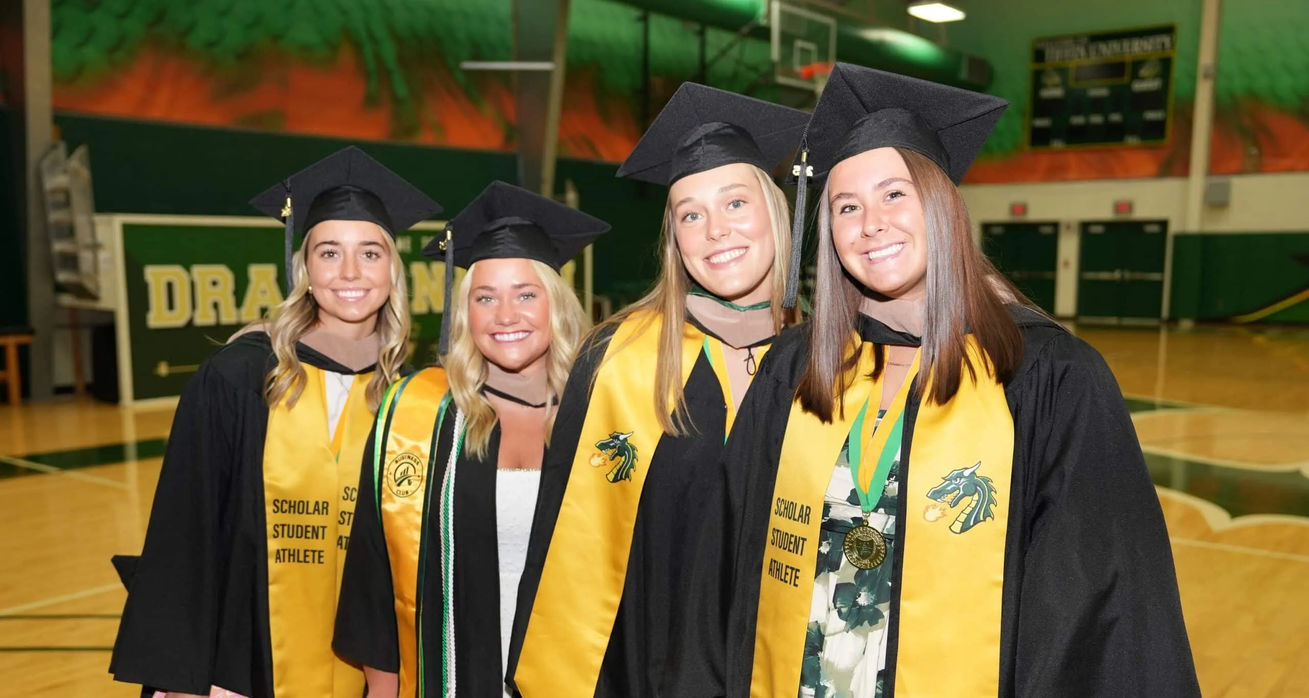 4 ladies smiling for the camera in regalia