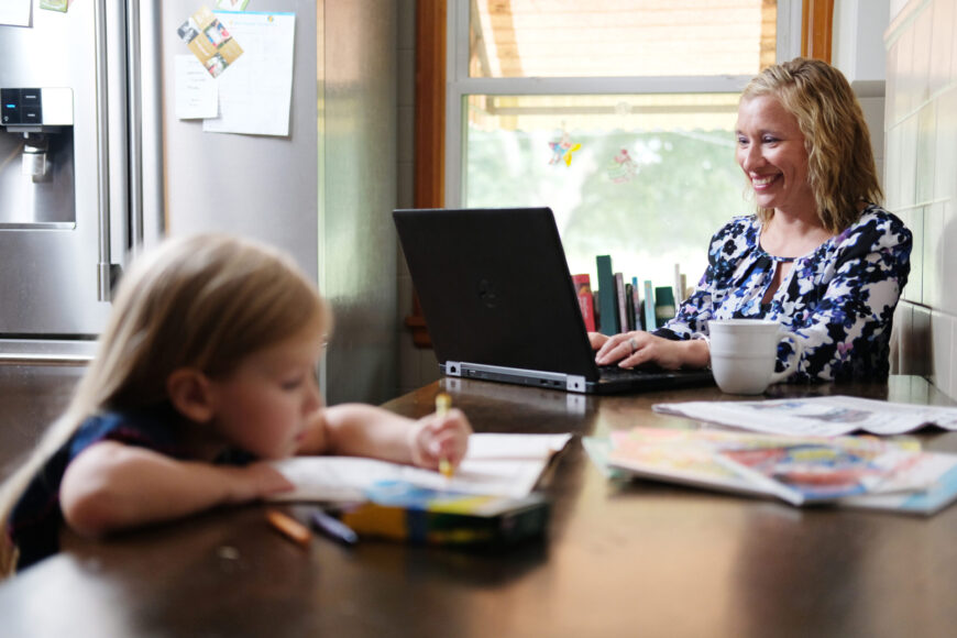 adult learner on laptop with child