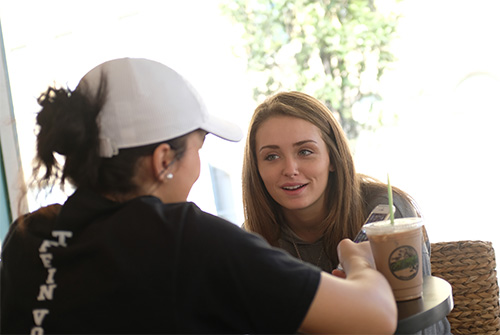 two students talking over coffee