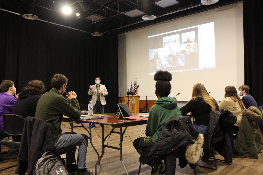 students looking at large screen in auditorium