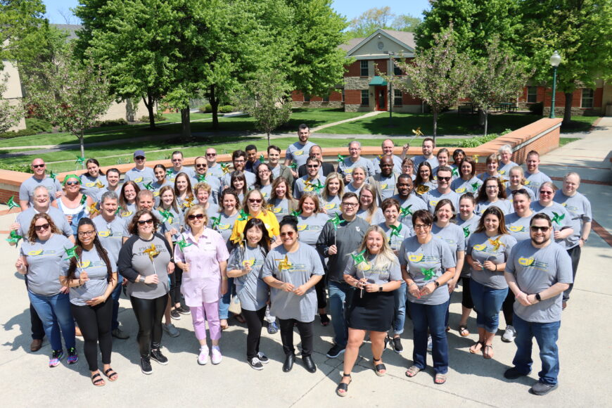 large group of employees outdoors smiling