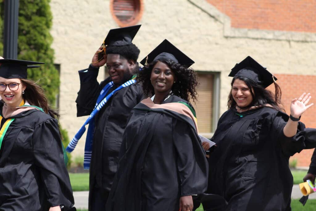 smiling students in cap and gown attire