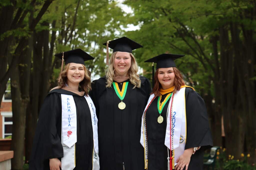 smiling students in cap and gown attire