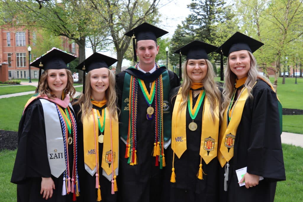 smiling students in cap and gown attire