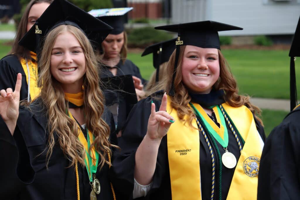 smiling students in cap and gown attire