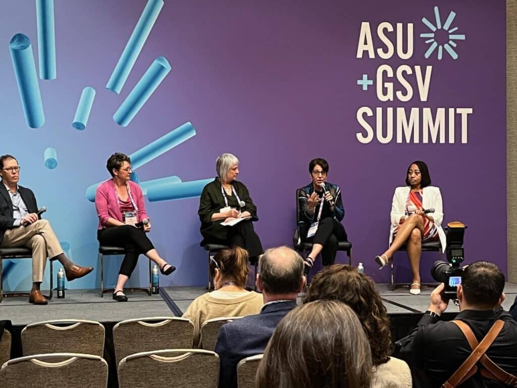 president schumacher sitting on a stage speaking