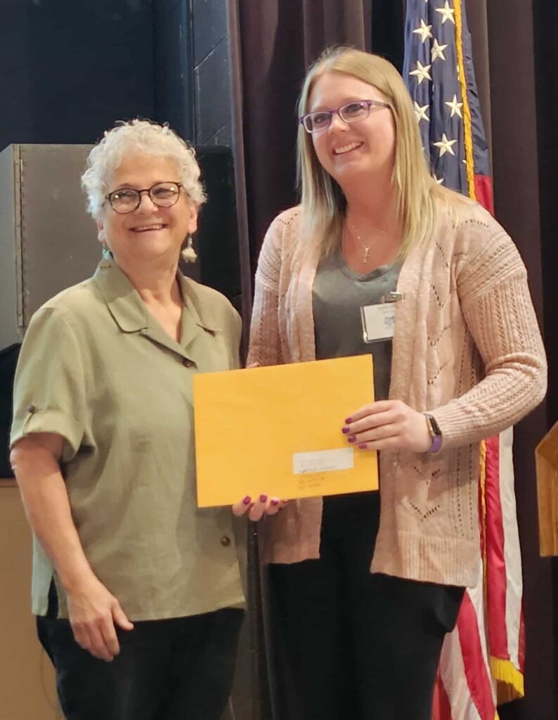 student with liz victor smiling with award