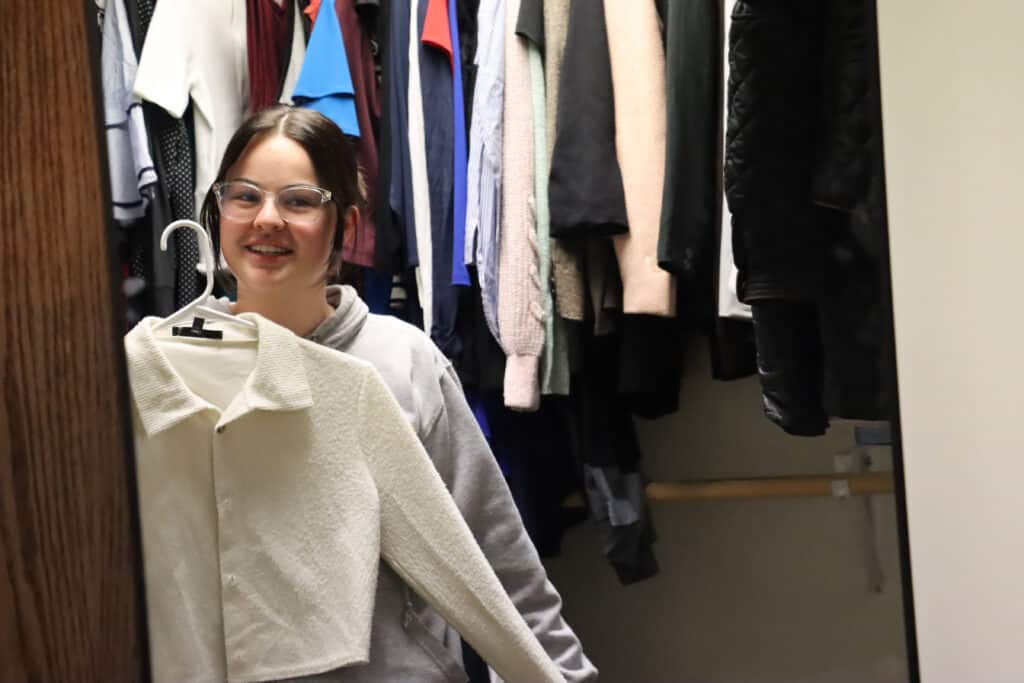 student smiling in mirror in dragon armoire