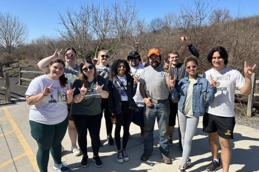 students smiling in a group photo on the alternative spring break trip