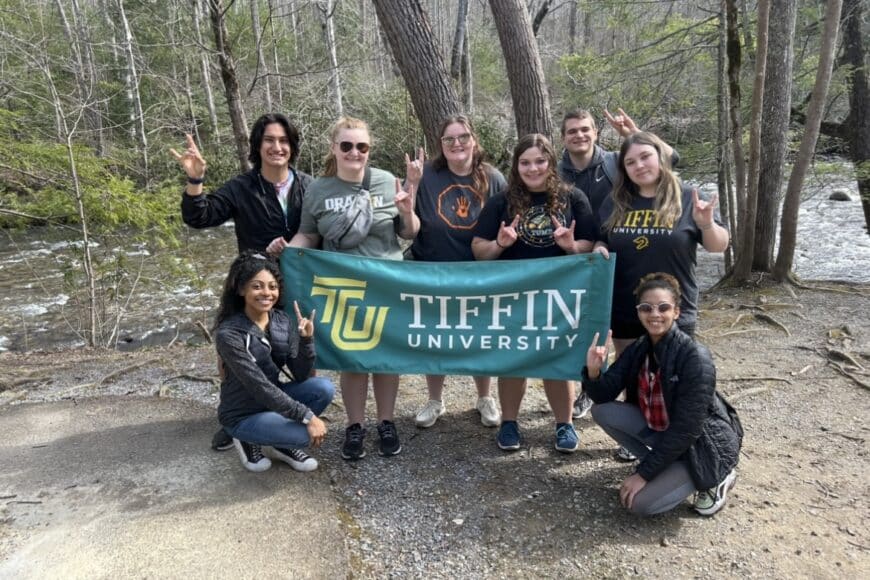 students smiling in a group photo on the alternative spring break trip