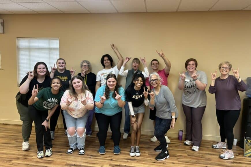 students smiling in a group photo on the alternative spring break trip
