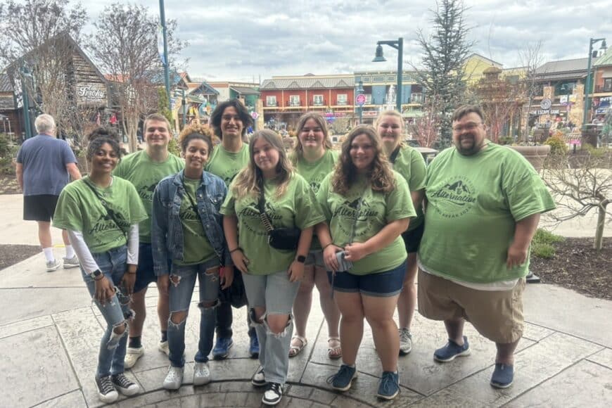 students smiling in a group photo on the alternative spring break trip