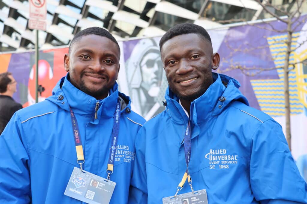 two smiling students in event services gear