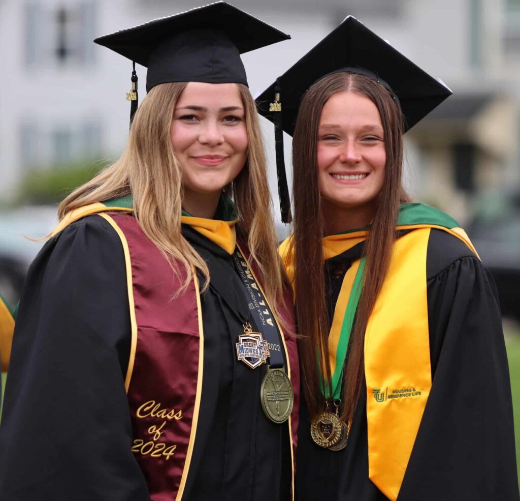 two smiling girls at graduation