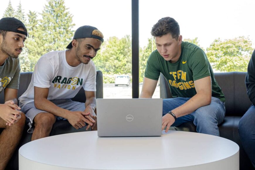 students looking at laptop in steam lobby