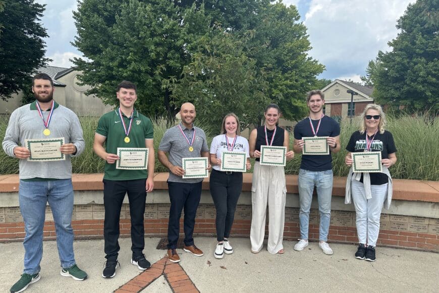 employees smiling with awards
