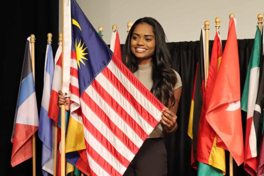 student smiling holding flag