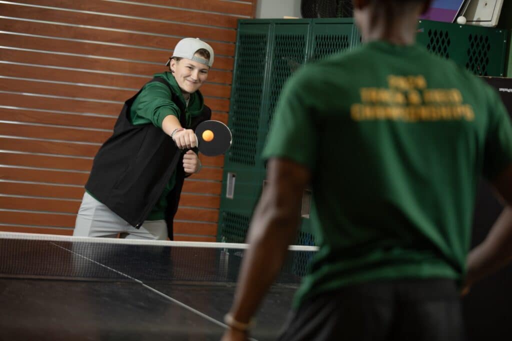 students playing ping pong in game room