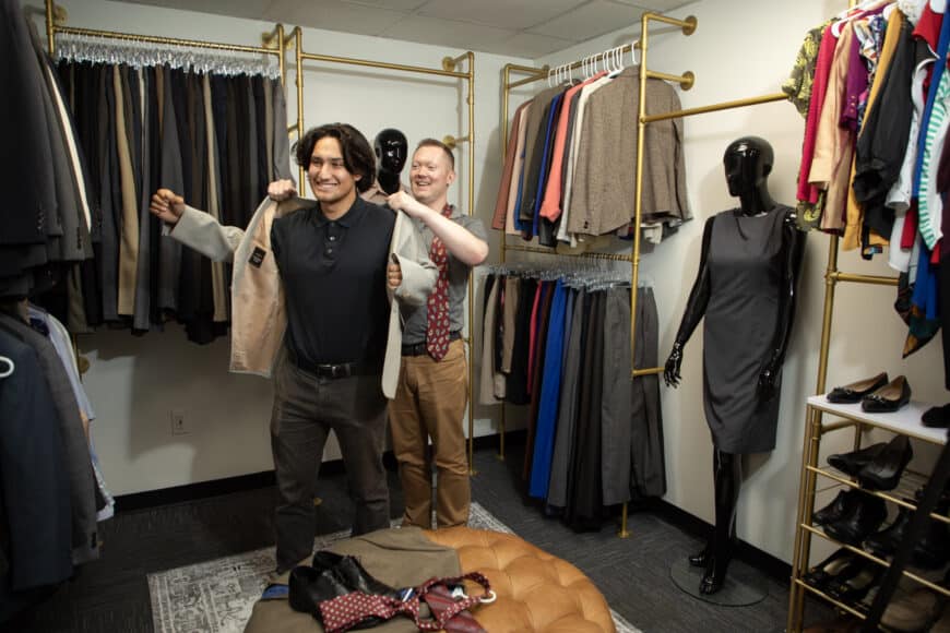 staff helping student put on jacket