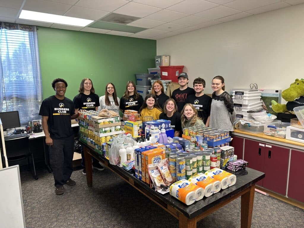 Students pose with food to be donated to a food bank