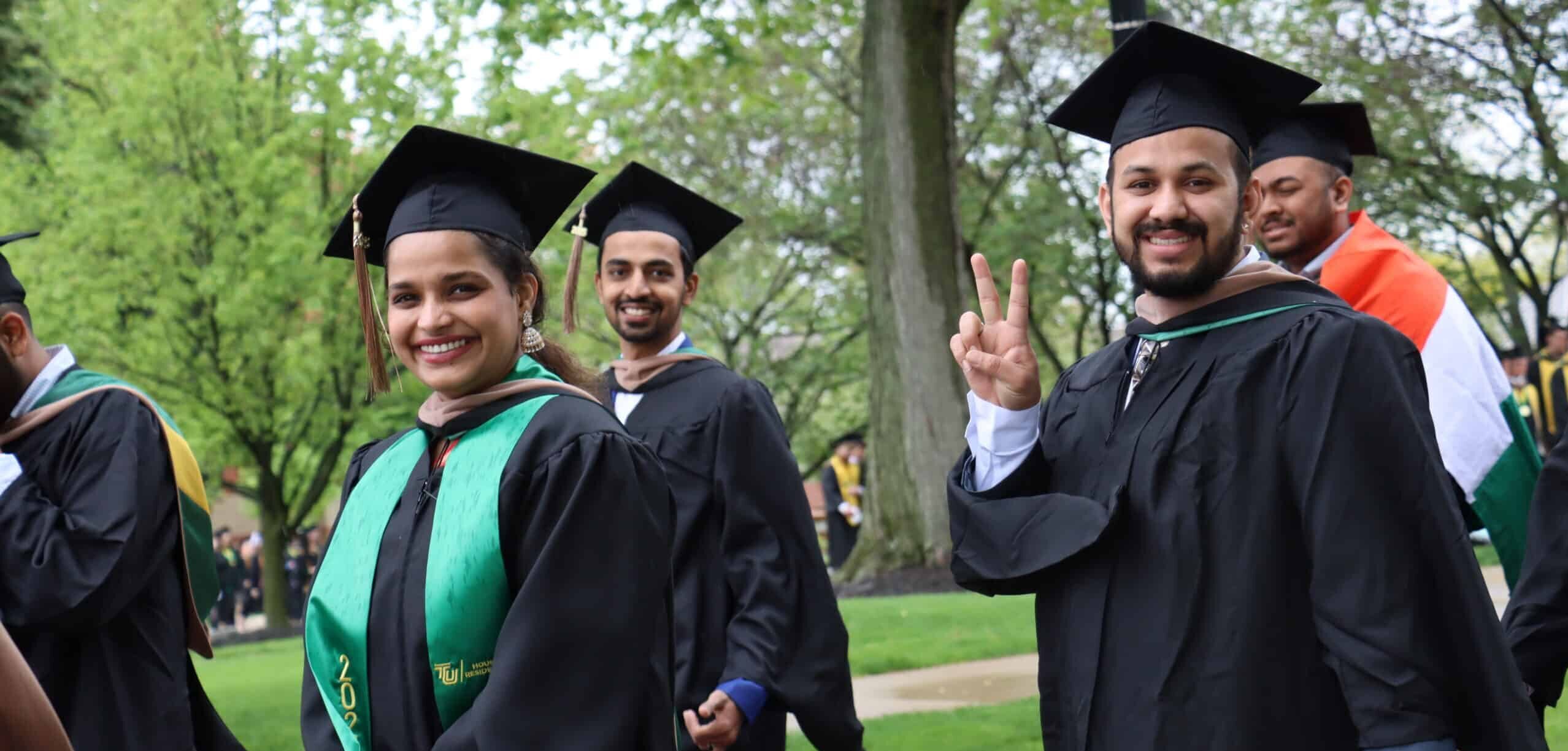people smiling and walking in graduation outfits