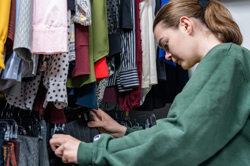 student looking at pants in dragon armoire