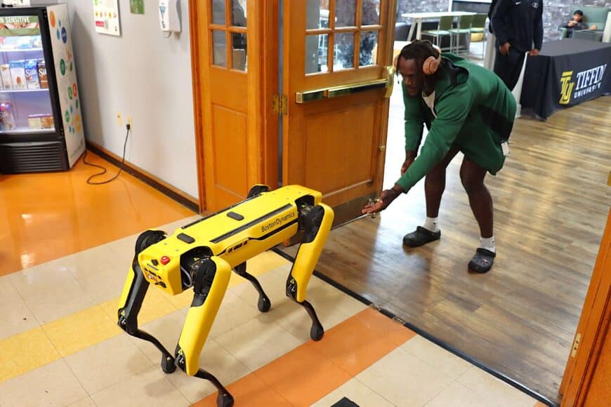 student greeting ai robotics dog, spot
