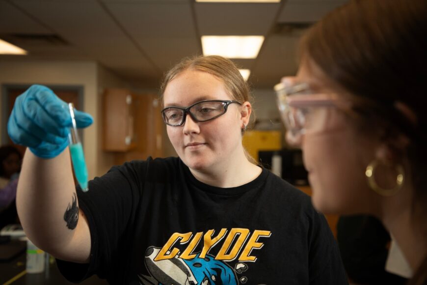 student looking at test tube in chemistry lab