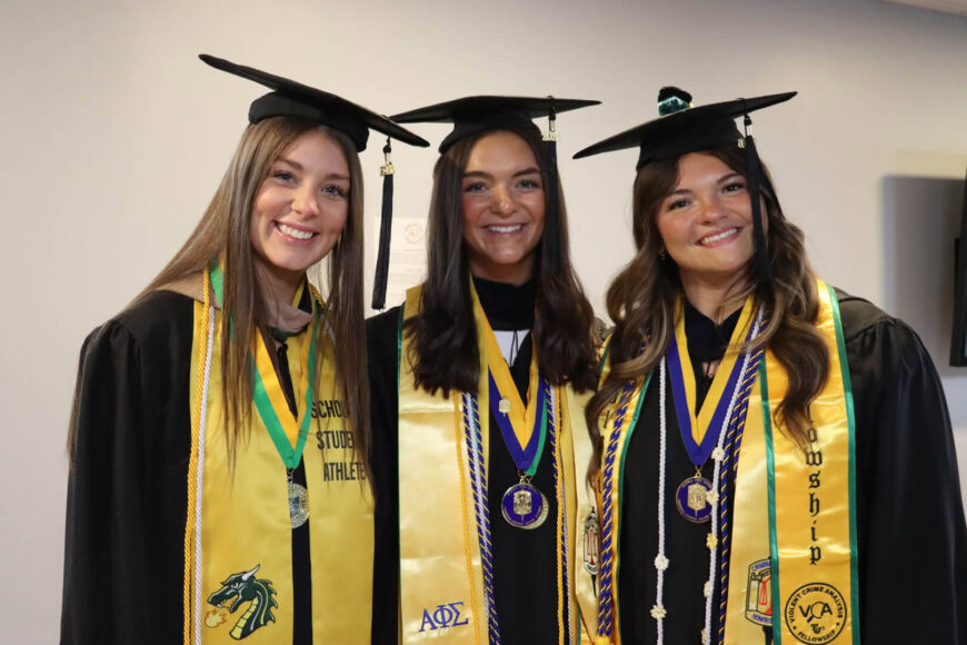 happy group at graduation in grad caps with stoles