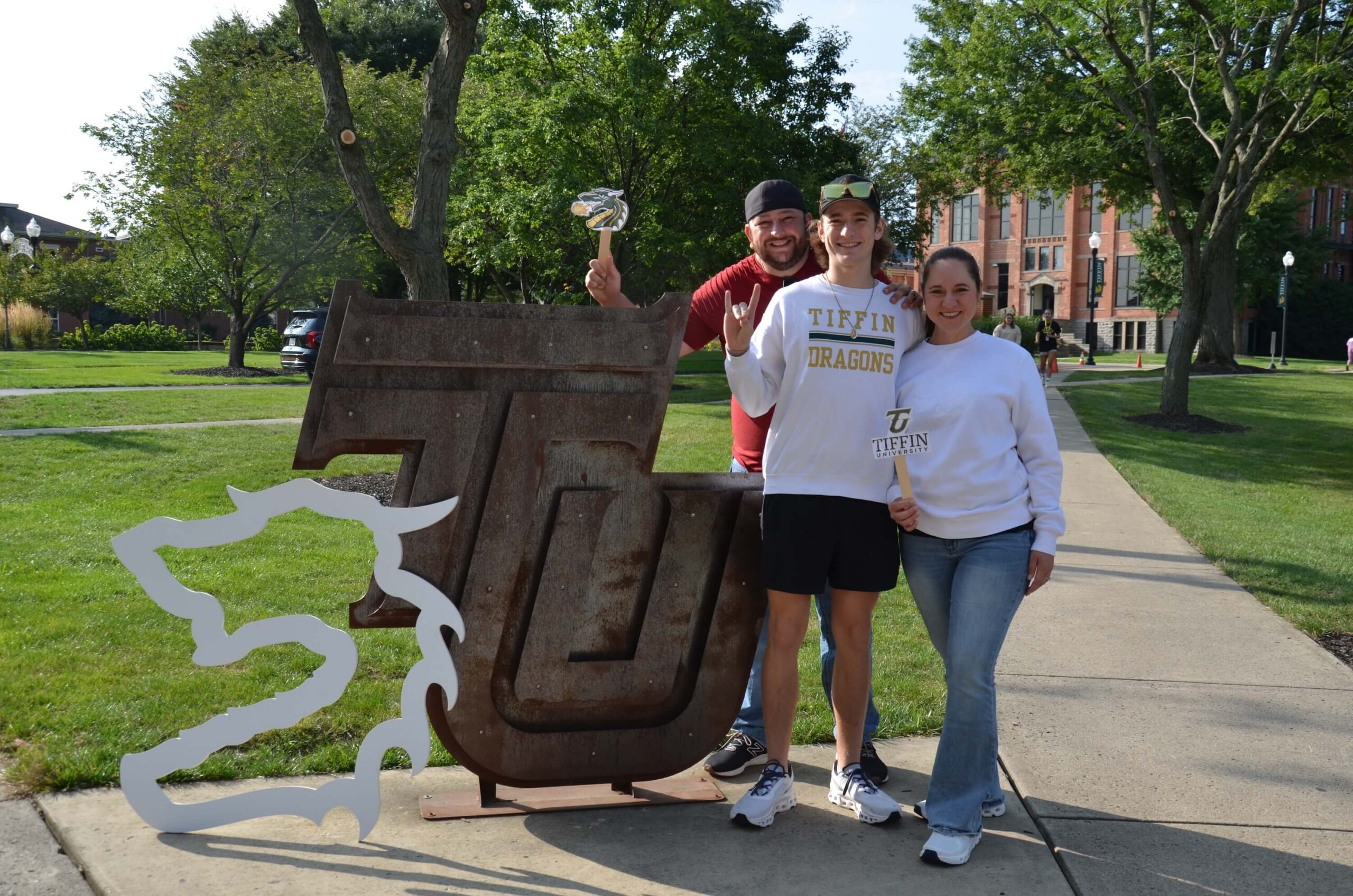 family posing with TU signage